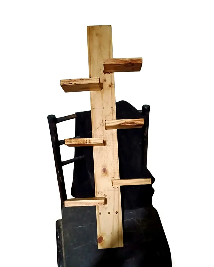 Repisa artesanal de madera de pino con 6 estantes, 80 cm de alto y tinte suave, apoyada sobre una silla